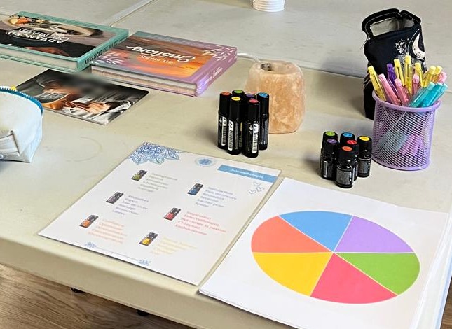 La table de l'atelier : flacons d'huiles essentielles, fiches, livres et feutres de couleur