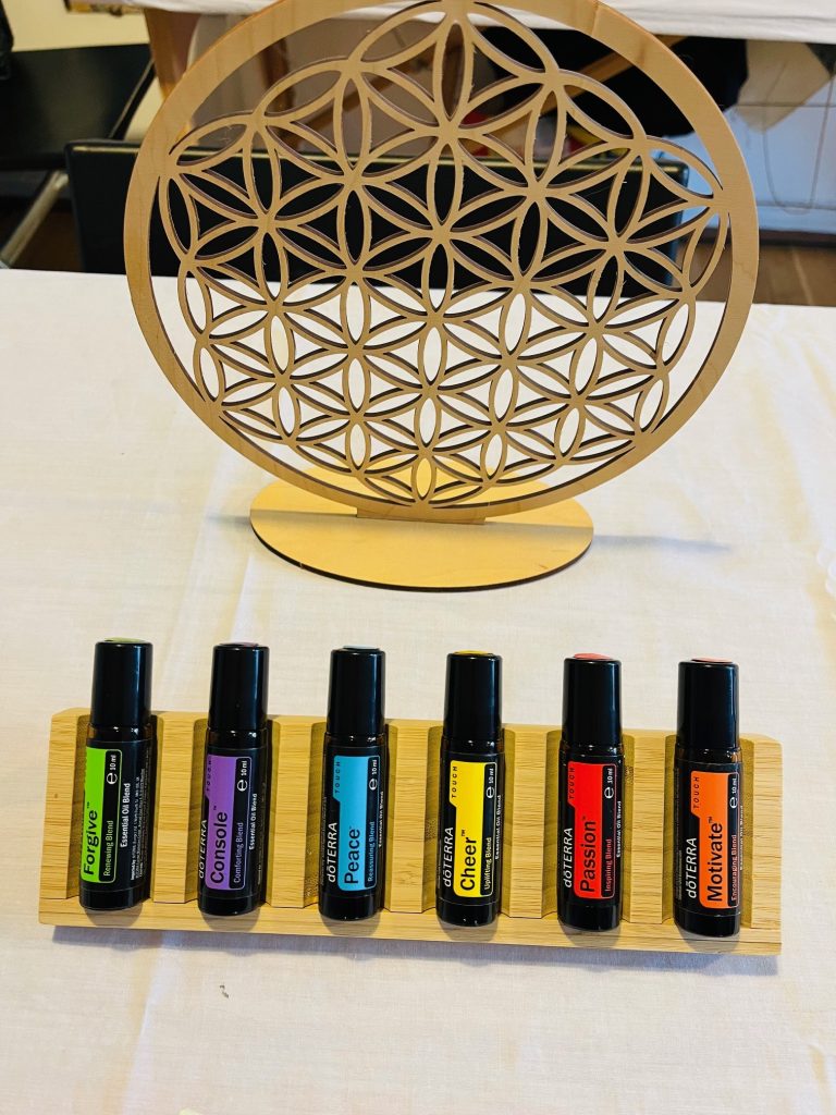 Une rangée de flacons de roll-on doTERRA sous une fleur de vie dorée